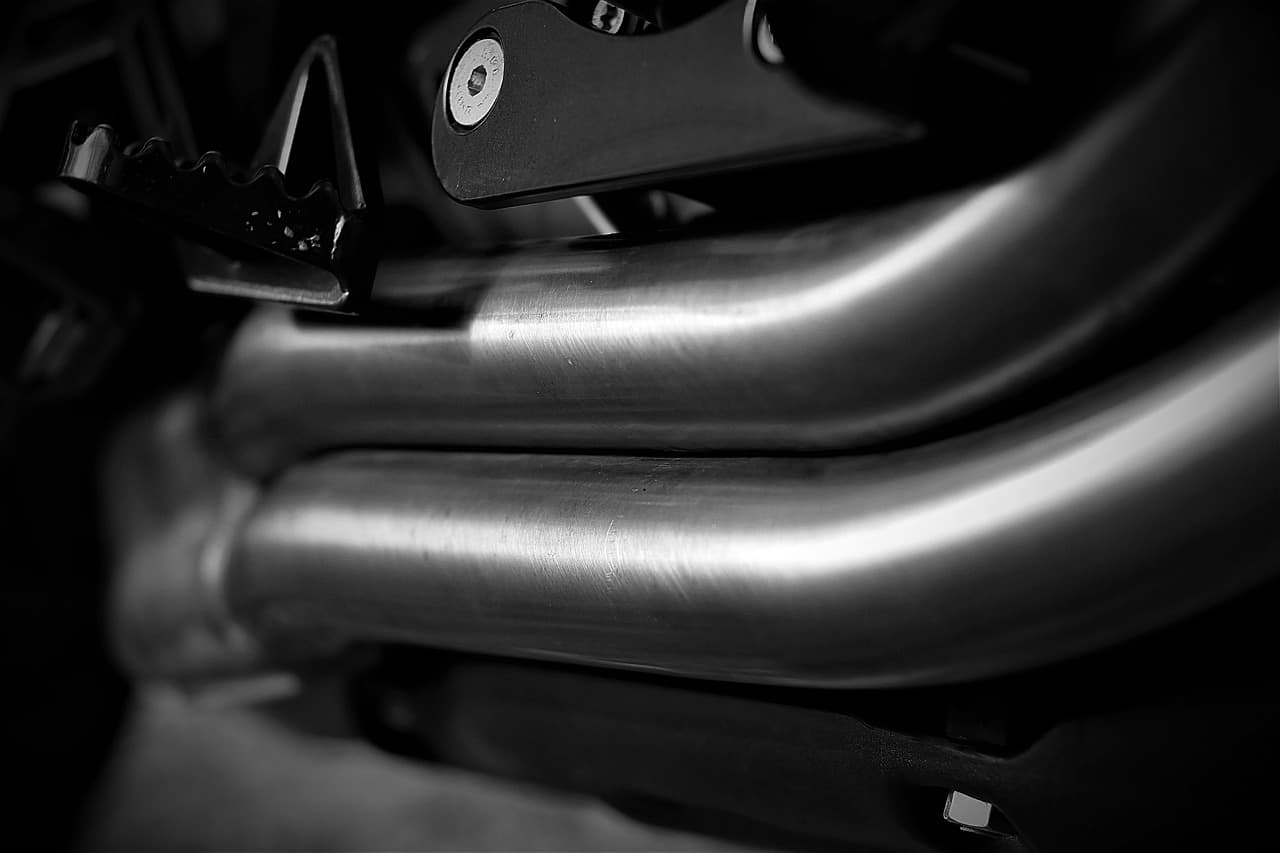 Close-up of polished exhaust header pipes bending side by side